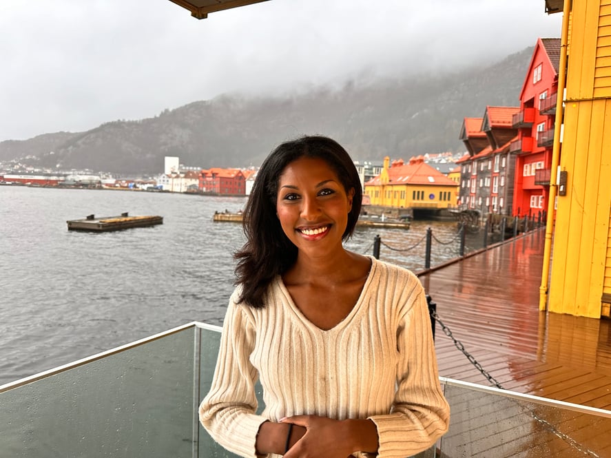 Susann smiler på brygge foran havet