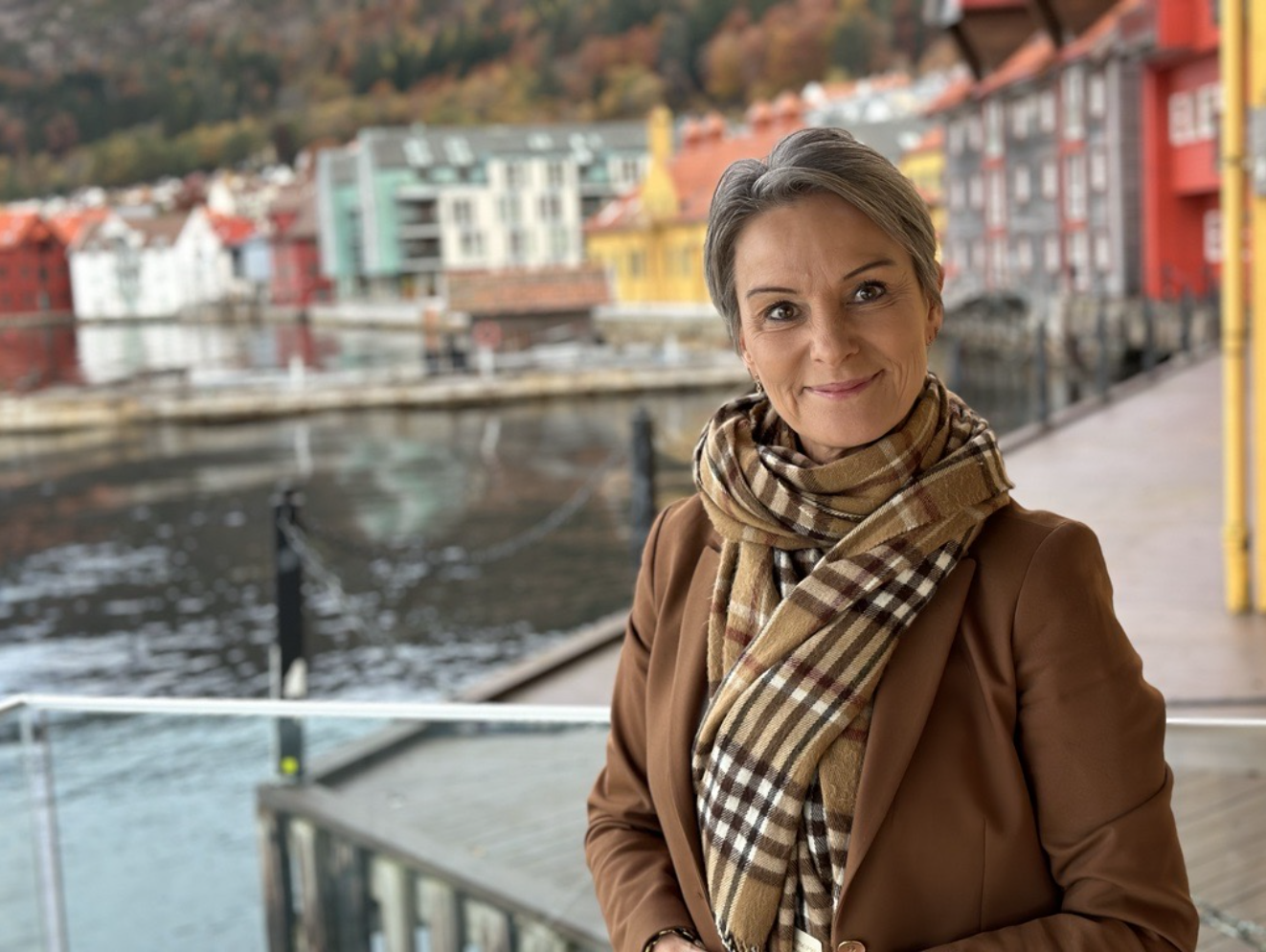 Michelle med brukt skjerf foran brygge og hav
