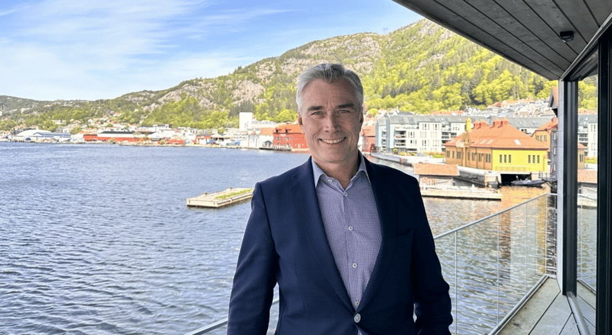 Sturle i dress som smiler foran havet