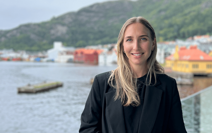 Kvinne (Lene) i svart dress foran hav