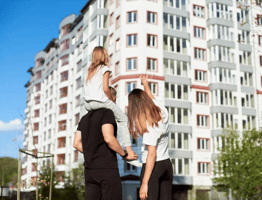 Bilde av en familie foran sitt nye hjem 