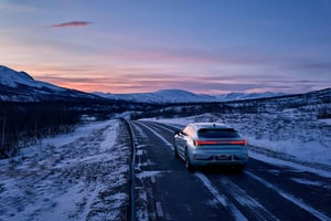 Bil som kjører i vinterlandskap og solnedgang
