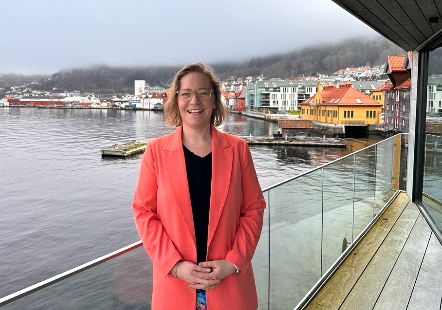 Smilende kvinne (Louise) i oransje blazer