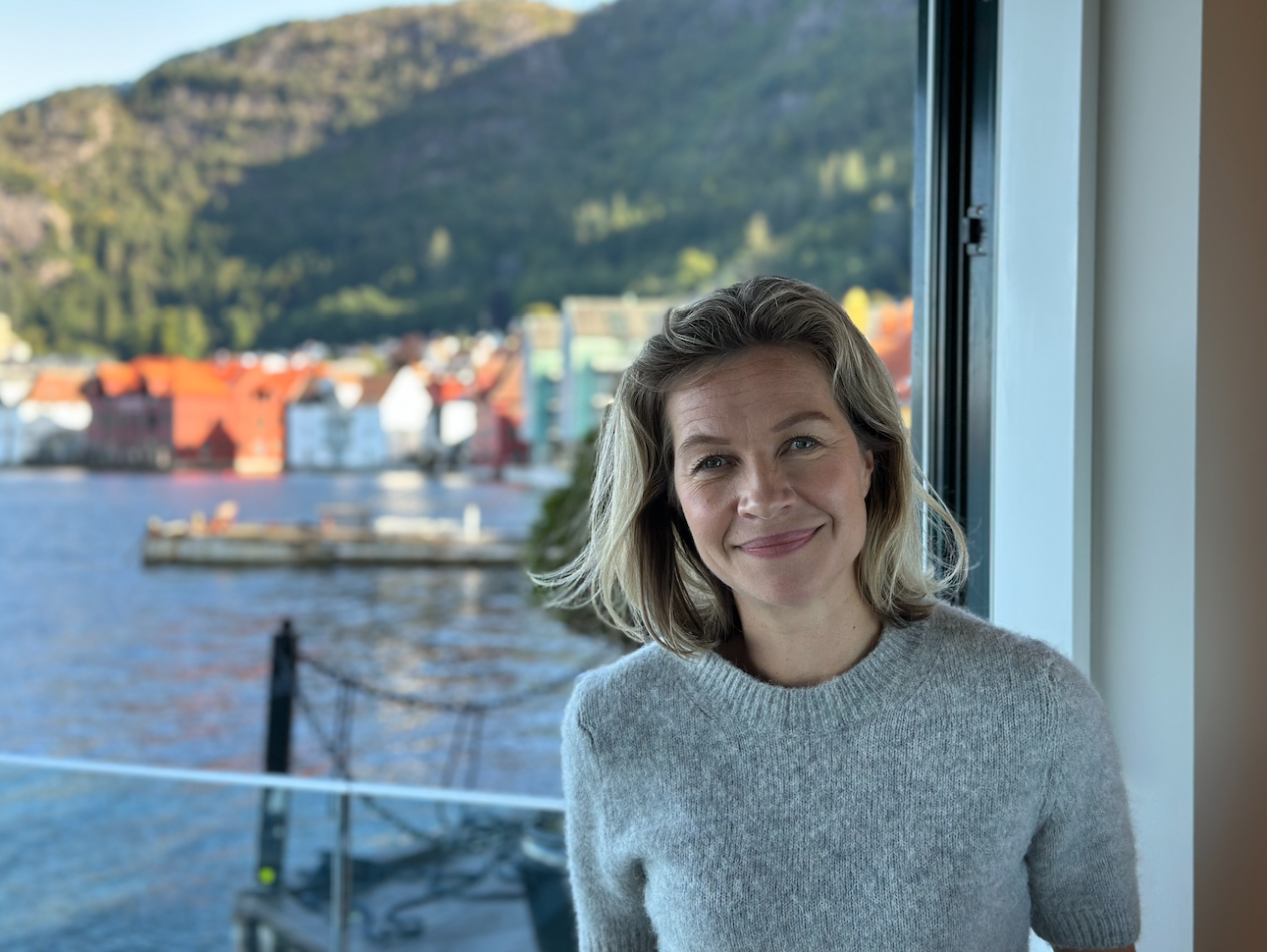 Henriette smiler foran solfylt sjø