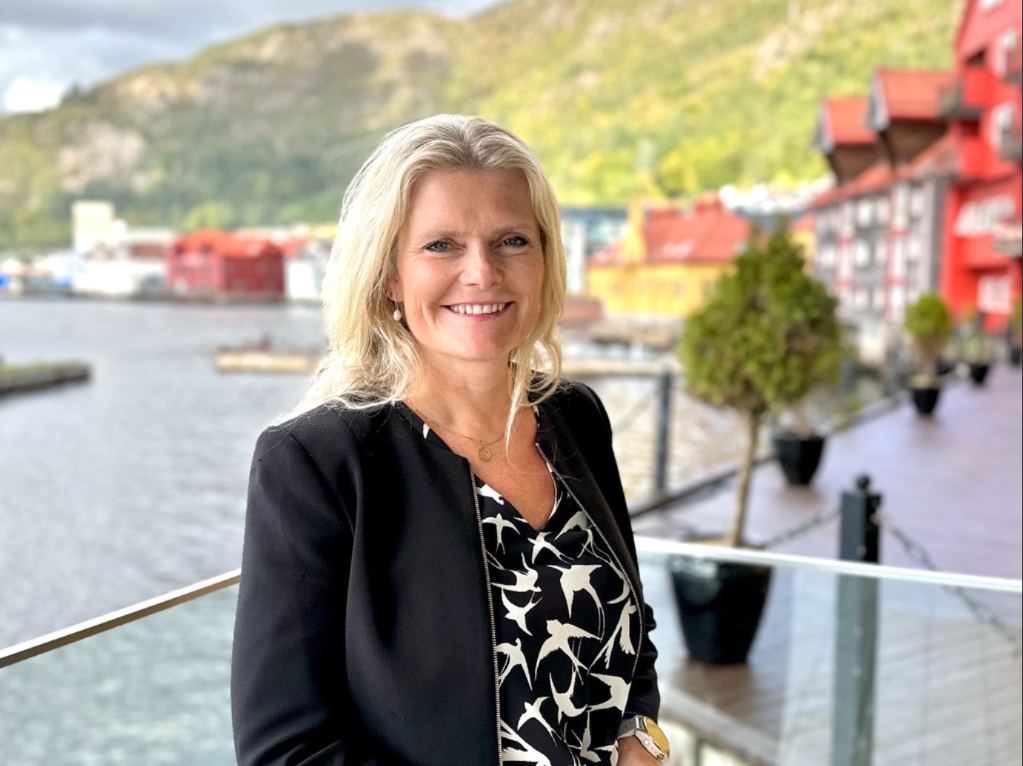 Peggy smiler foran solfylt sjø